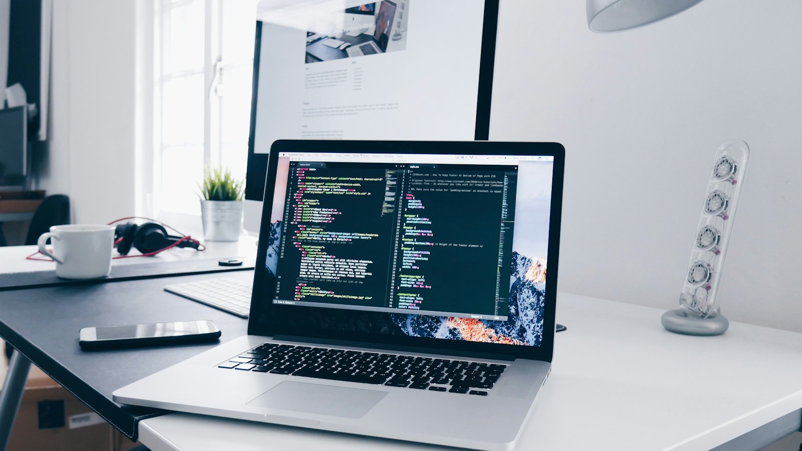 A visual no-code editor on one screen and a code editor with the same app's data model on the other